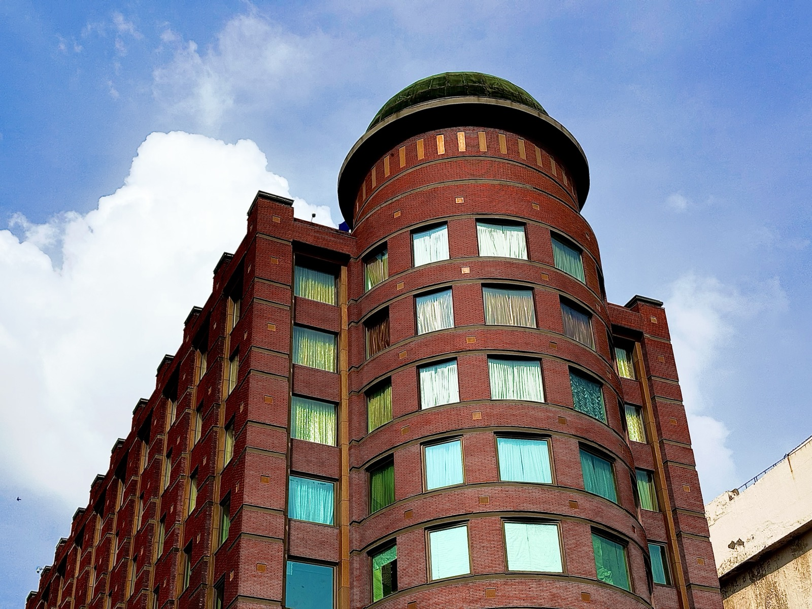 Red-brick tower rising into a bright blue sky