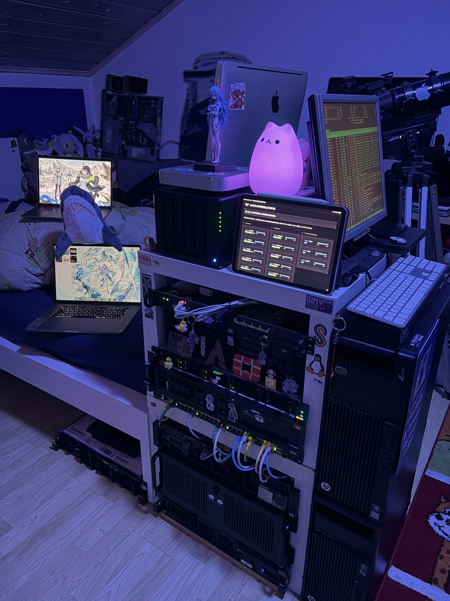 Blue-lit homelab with servers, computers, and several displays