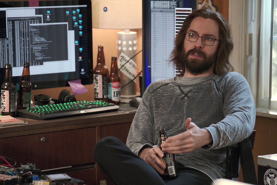 A Silicon Valley still of a programmer relaxing beside computers